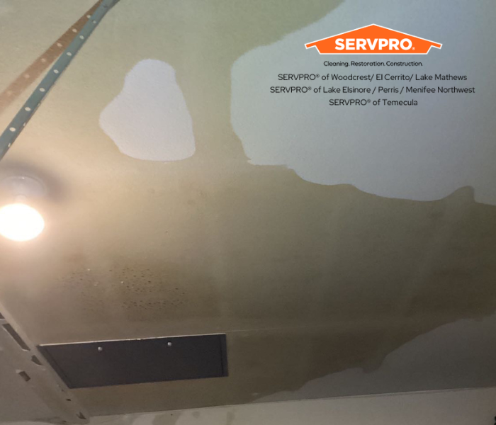 picture is of a garage ceiling that took in water damage and has water spread around the area